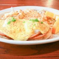 Eggs Benedict · Poached eggs with grilled ham on an English muffin, topped with hollandaise sauce, served wi...