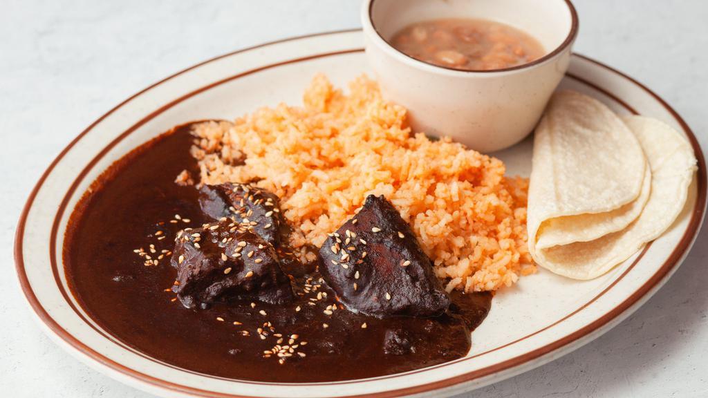 Chicken Mole · One of Mexico’s more traditional plates, mole is made with a variety of 4 chiles, chocolate and special spices, served with beans, rice, and choice of Tortillas