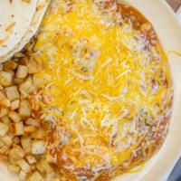 Huevos Rancheros · Homemade refried beans on a corn tortilla with two eggs smothered in homemade pork green chi...