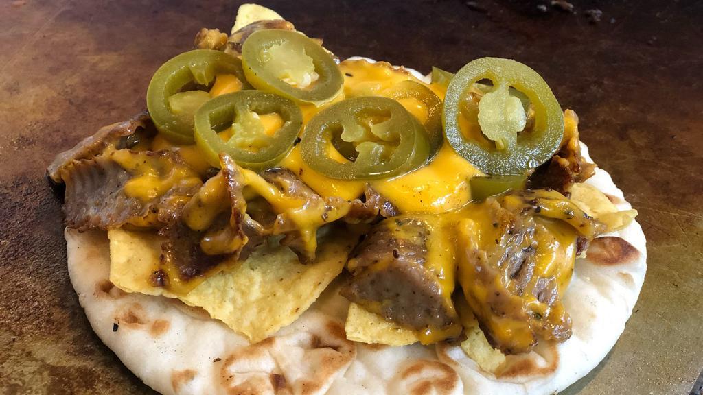 Nacho Cheese Gyro · Try the new Nacho cheese gyro! Gyro topped with nacho cheese, tortilla chips, and spicy jalapeños. Everything you love about Nachos merged into a gyro!