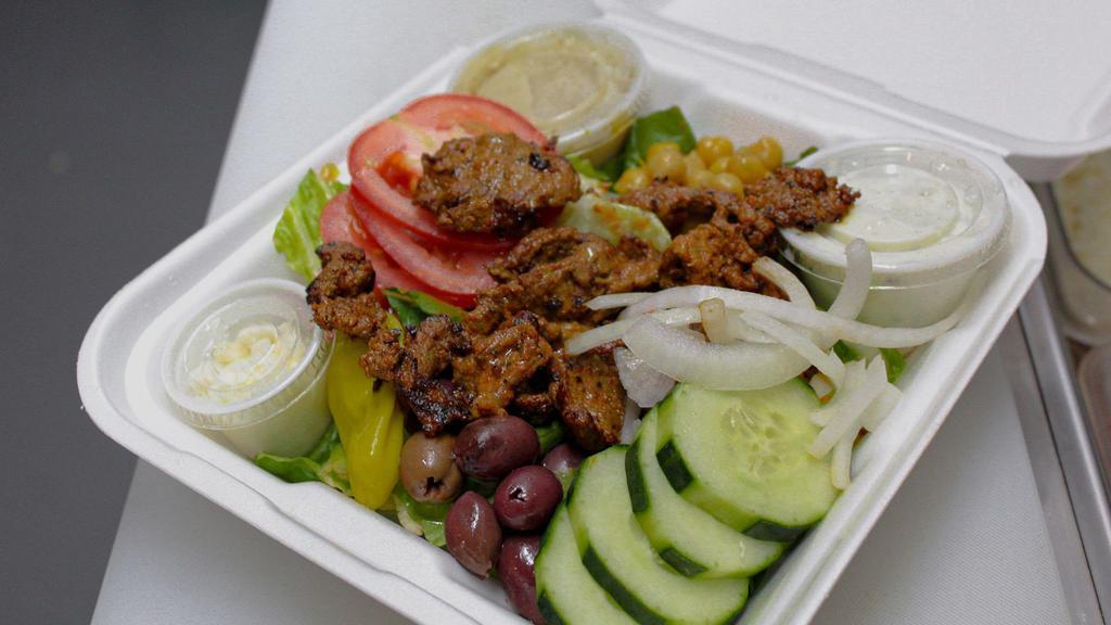 Beef Shawarma Salad · Beef shawarma on-top of romaine lettuce. Includes feta, cucumber, tomato, onions, greek olives, chickpeas, greek dressing and a cup of tzatziki sauce.