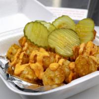 Spicy Yum Yum Tot-Box · Tater tots topped with spicy sriracha mayo sauce, grilled onions and pickles.
