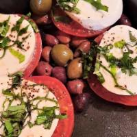 Mozzarella Caprese · Vine ripened tomatoes, fresh mozzarella, basil, and virgin olive oil.