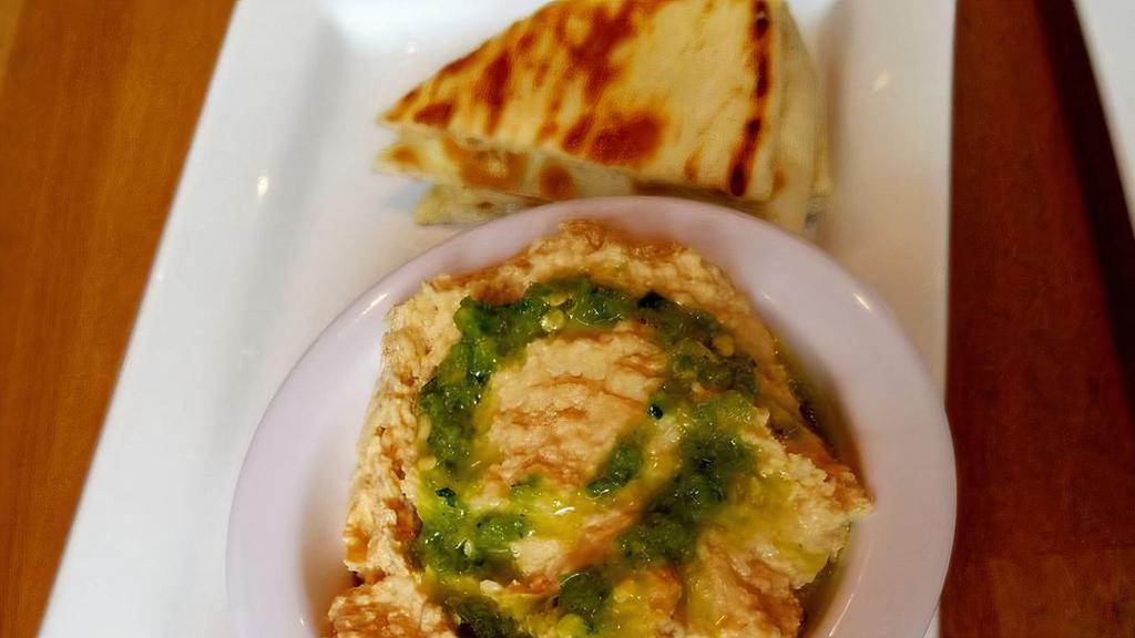 Hummus And Pita · Homemade hummus and grilled pita bread. Topped with our house spicy sauce.