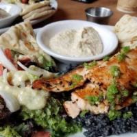 Salmon Plate · Grilled salmon served over squid ink rice with hummus, pita and side salad. Includes tomato,...