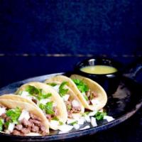 Street Tacos · 4 street tacos filled with chile colorado topping with onions and cilantro served with a sid...