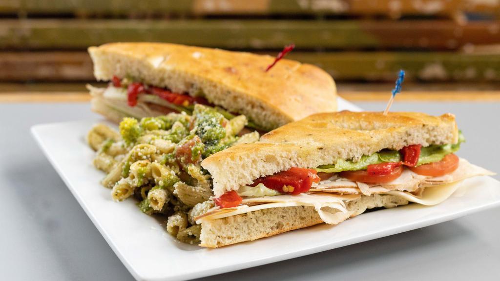 Torino · Smoked turkey breast, focaccia bread, provolone cheese, romaine, roasted red peppers, roma tomatoes, pesto, side pasta salad.