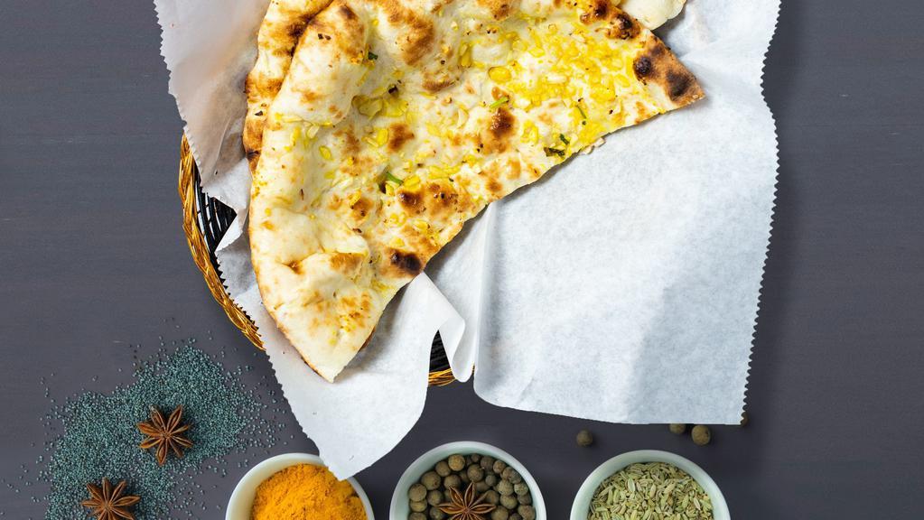 Garlic Naan · Freshly baked bread in a clay oven garnished with garlic and butter.