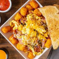 Piggy Scrambler · Eggs scrambled with sautéed ham, bacon and poblano peppers topped with melted mixed cheese o...