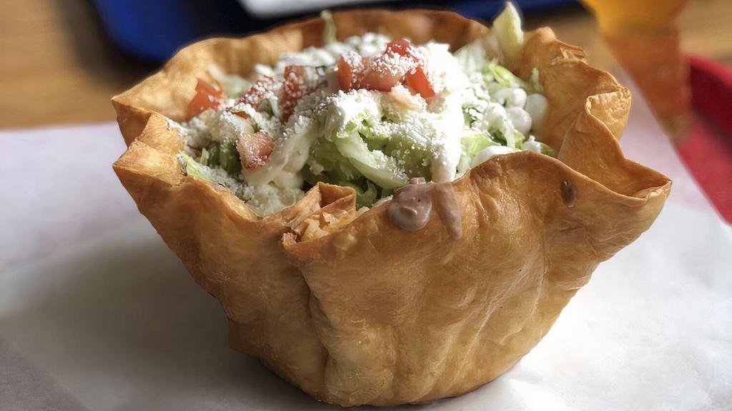 Taco Salad · Crispy flour tortilla, choice of meat, rice, beans, lettuce, onions, cilantro, tomatoes, sour cream, guacamole, Monterey jack cheese & cotija cheese.