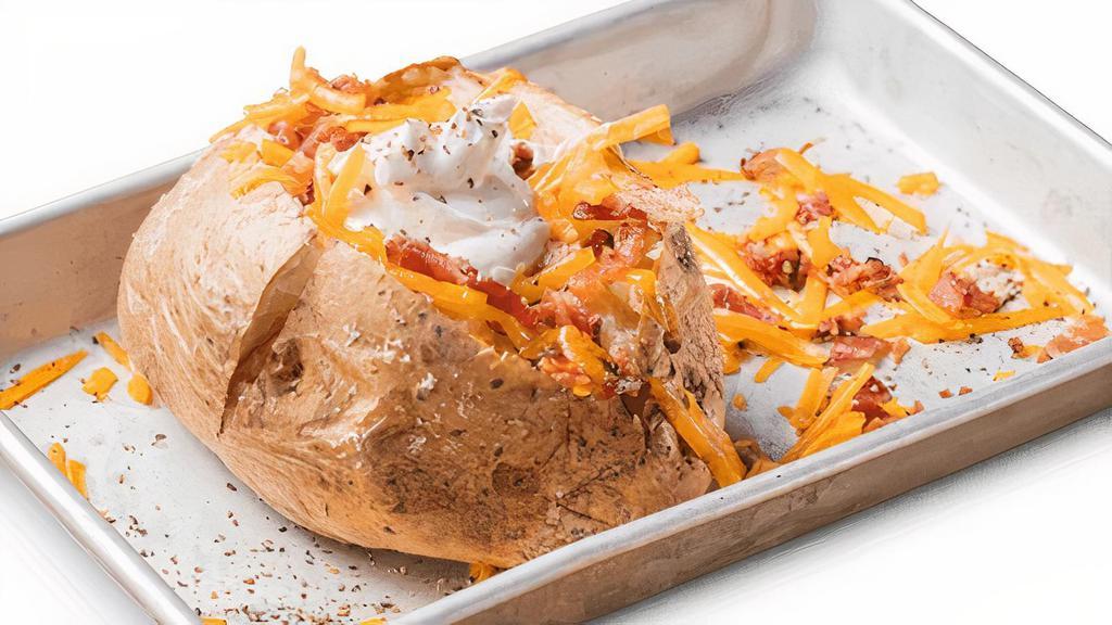 Loaded Baked Potato · Baked potato topped with shredded cheddar cheese, bacon, sour cream and whipped butter. Served with choice of one side and a Corn Bread Muffin.