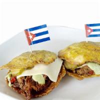 Tostones Rellenos · Plantain sandwich. Deep fried smashed plantain, Swiss cheese, pickle, your choice of shredde...