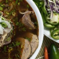 Bún Bò Huế - Spicy Beef Noodle · Thick, round rice noodles in a spicy lemongrass beef broth with slices of beef shank, beef b...