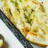 Garlic Naan · Traditional flat breads cooked in our tandoor clay oven