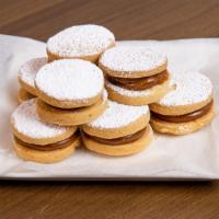 Peruvian Alfajores · A dozen cookies with caramel filling and powdered sugar on top.