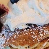 Full Blueberry Pancakes · Six of our buttermilk pancakes filled with fresh plump blueberries. Served with a side of Wh...