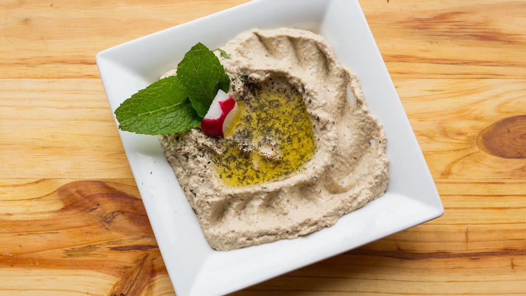 Baba Ghanouje · Local hand roasted eggplant mixed with tahini sauce, lemon juice and garlic - served with olive oil.