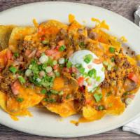 Super Nachos · Crisp corn chips, topped with melted cheese, refried beans, fresh tomato, guacamole, and sou...