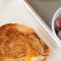 Kids Grilled Cheese · Sliced wheat bread, mozzarella, cheddar. Served with fruit and choice of milk or juice.