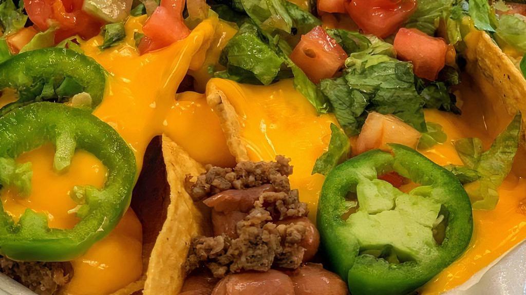 Alinstante Nachos · Chips, ground beef, beans, jalapeños, lettuce, tomato, and nacho cheese.