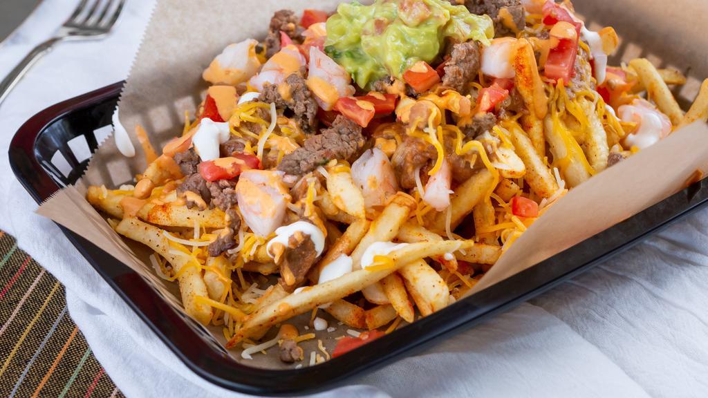 Carne Asada Fries · Golden fries loaded with carne asada, guacamole, cheese, and sour cream.