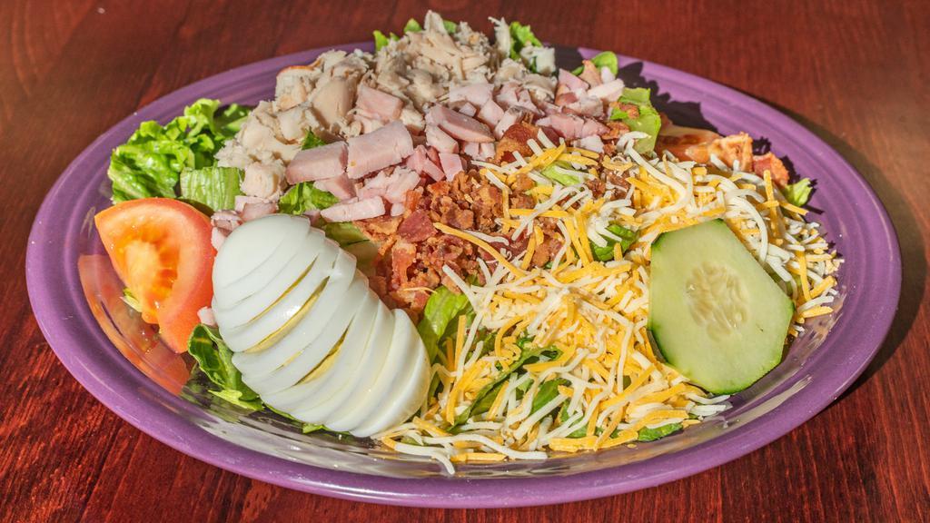 Chef Salad · Fresh mixed greens topped with ham, turkey, chopped bacon, cheddar cheese, hard boiled egg and tomato with choice of dressing.