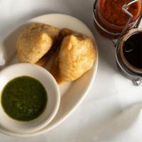 Samosa · Two crispy pastries stuffed with your choice of mixed vegetables or minced lamb.
