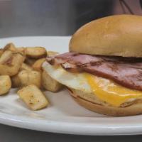 Breakfast Sandwich · fried eggs, choice of ham or bacon, cheddar cheese. Served with home fries and toast