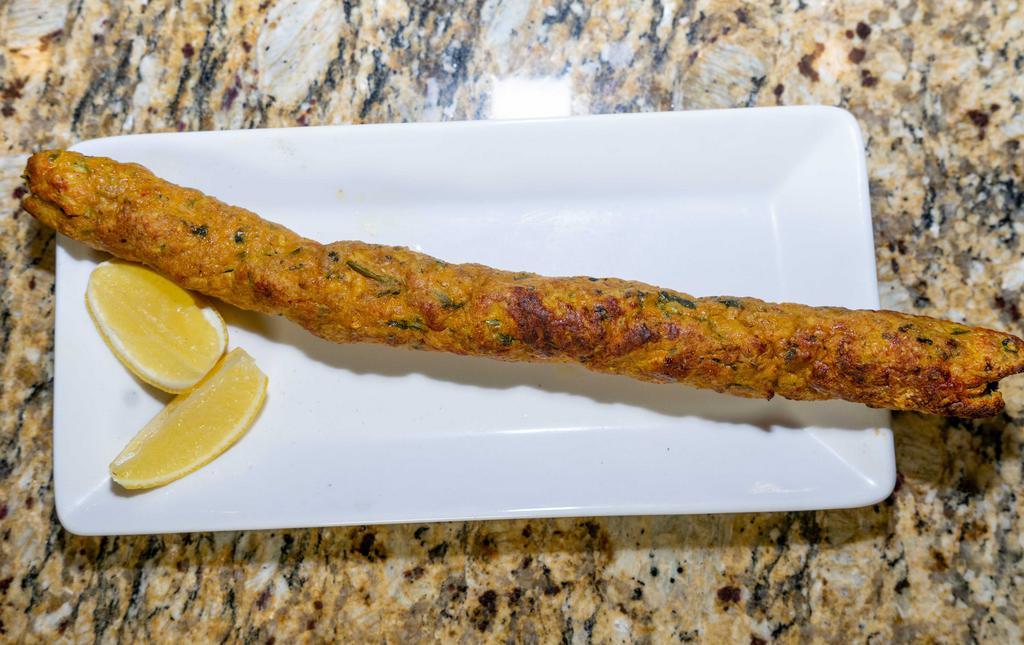 Chicken Seikh Kebab - Single · Prepared with ground chicken meat with herbs and Indian spices rolled on skewers and finished in tandoor. Served on a plate with mint and tamarind chutneys.