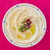 Hummus · A blend of chickpeas purée with garlic lemon juice & tahini. Served with a drizzle of olive ...