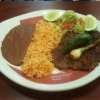 Carne Asada  · Broiled beef flap meat. Served with rice, beans, salad and corn tortilla .