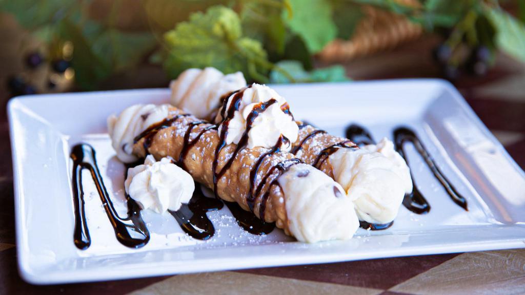 Sweet Cannolis · Two sweet Cannoli shells (Fried Pastry Dough) filled with a sweet creamy mixture of ricotta cheese, cream cheese, chocolate chips, topped with a drizzle of chocolate and dusted with powdered sugar. Great for sharing.