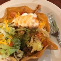 Taco Salad · Crispy tortilla bowl layered with beans, lettuce, cheddar cheese, tomato, salsa roja, sour c...