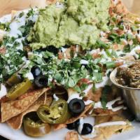 Nachos · With queso, black beans, olives, jalapeños, green onions, tomatoes, salsa, crema, guacamole.
