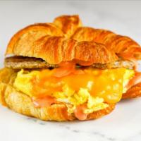 Sausage, Egg And Cheddar Croissant Sandwich · 2 scrambled eggs, melted Cheddar cheese, breakfast sausage, and Sriracha aioli on a warm cro...