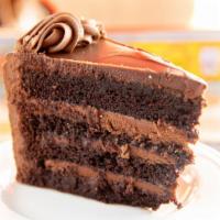 Triple Fudge Lust Xxx Cake Slice · Chocolate cake with fudge filling and icing dripped with chocolate ganache.