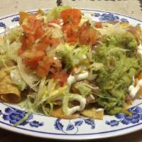 Super Nachos · Corn tortilla chips topped with refried beans, your choice of meat, cheese, sour cream, guac...