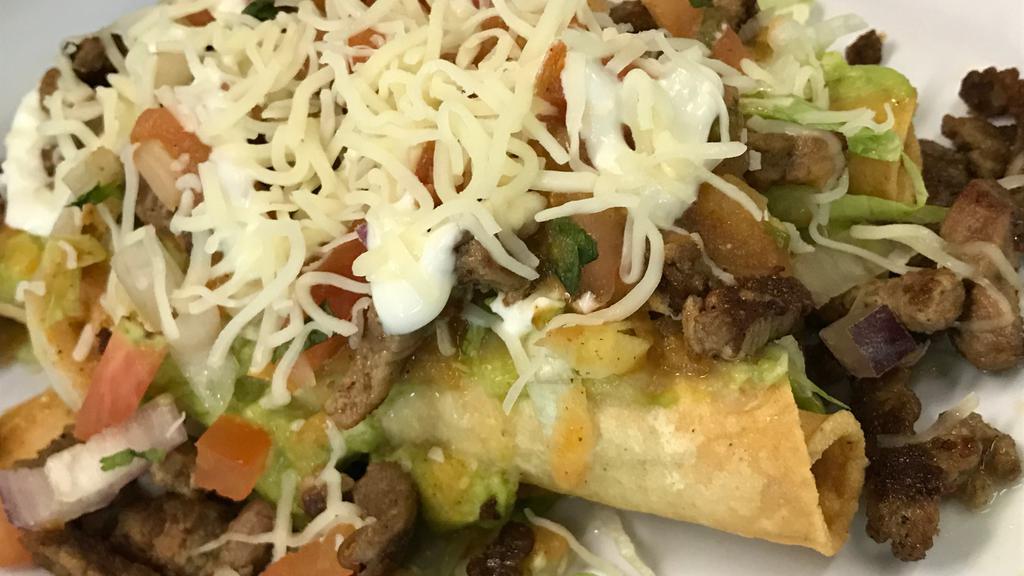 Flautas Supreme (5) · Five shredded beef flautas (rolled tacos) topped with cheese, carne asada, pico de gallo, lettuce, tomato sauce and sour cream.