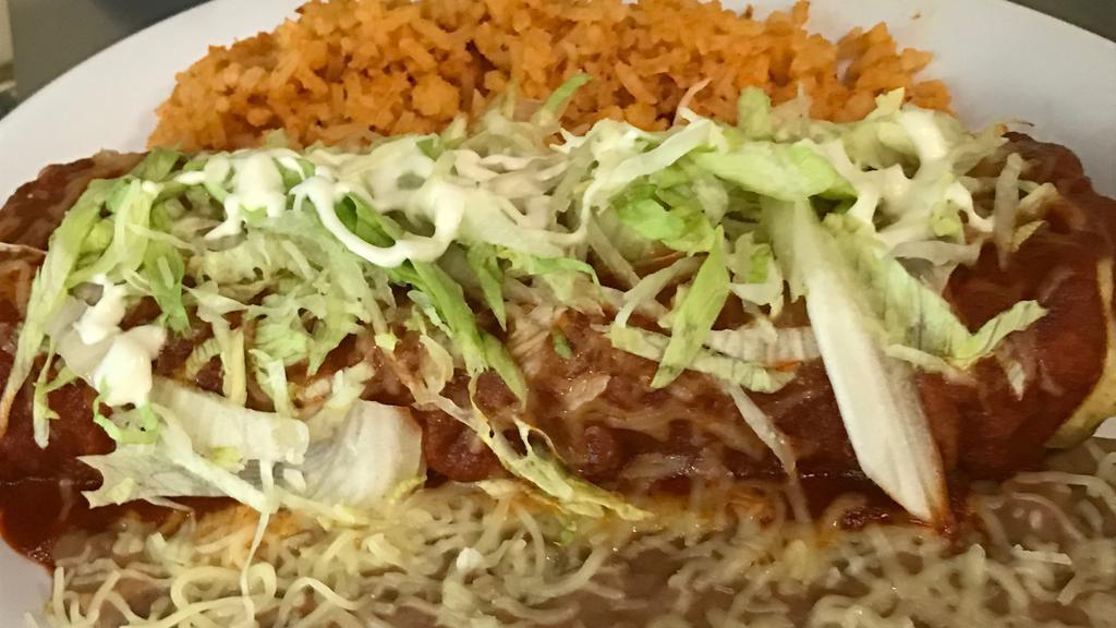 Chimichanga Platter · Chimichanga with your choice of meat and cheese inside. Topped with enchilada sauce, cheese, lettuce and sour cream.
Served with rice and beans.
