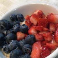 Bowl Of Oatmeal With Fresh Fruit · Hot oatmeal served with chopped strawberries and blueberries.