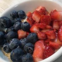 Cup Of Oatmeal With Fresh Fruit · Hot oatmeal served with chopped strawberries and blueberries