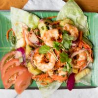 Plar Goong · Grilled large shrimp tossed with fresh garden spices, lettuce, hot peppers and fresh lime ju...