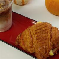 Breakfast Starter · Fresh croissant, melted cheddar cheese, ham, and a warm fluffy scrambled egg. With house mad...