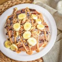 Monkey Business · Peanut butter griddle cakes, whipped cream, bananas, walnuts and chocolate drizzle.