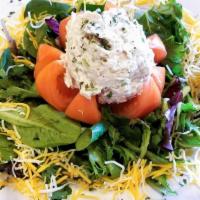 Tuna In Tomato Salad Lunch · Tomato stuffed with albacore tuna salad on a bed of mixed greens.