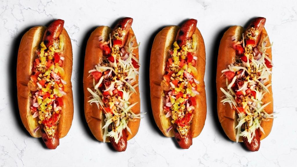 The Windy City Style Hot Dog · A footlong hotdog topped with yellow mustard, chopped white onions, sweet pickle relish, tomato slices, pickled sport peppers and a dash of celery salt on a warm griddled bun.
