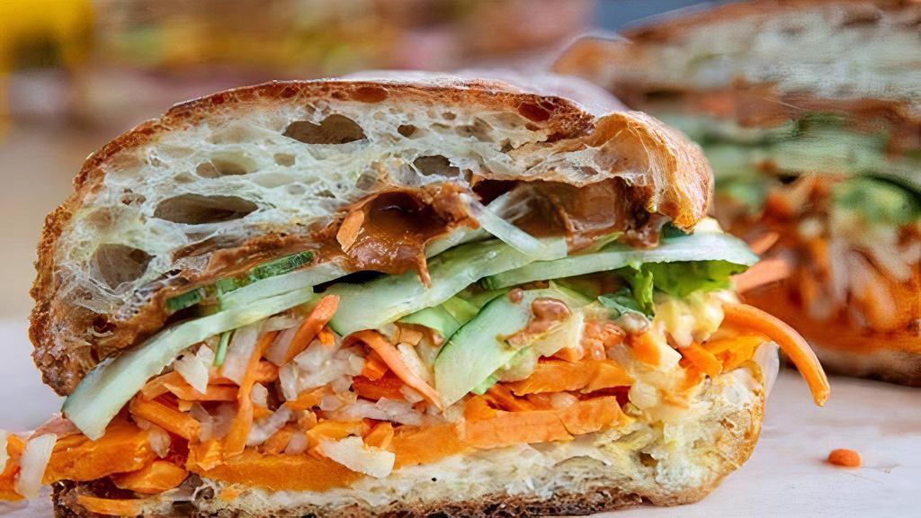 Massaman Curry Banh Mi Sandwich · Roasted yams, spicy peanut butter, cucumber, jalapeno, pickled carrot, daikon radish, and spicy coconut curry aioli cilantro. Served with choice of lemon tree co. salad, and savory oats, or chips.