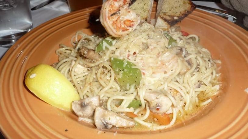 Spaghetti Alla Scampi · Tiger prawns, garlic, tri-colored peppers and mushrooms in a white wine sauce.