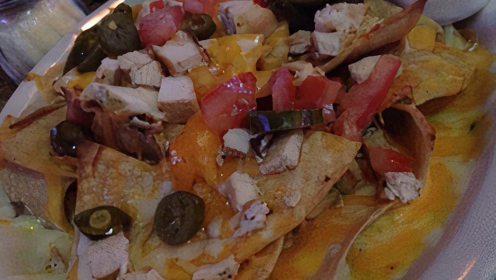 Lucky’S Nachos · Crispy tortilla chips topped with freshly shredded cheese, black olives, jalapeño, tomatoes, and red onion. Served with a side of sour cream and housemade salsa.