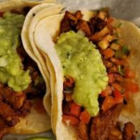 Pastor Taco · Marinated pork strips, seasoned and grilled, then topped with guacamole, and pico de gallo.